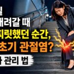 계단에서 내려오는 여성이 무릎 통증으로 멈춰서 있다.